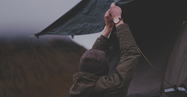 man pulling rip stop tarp into securement